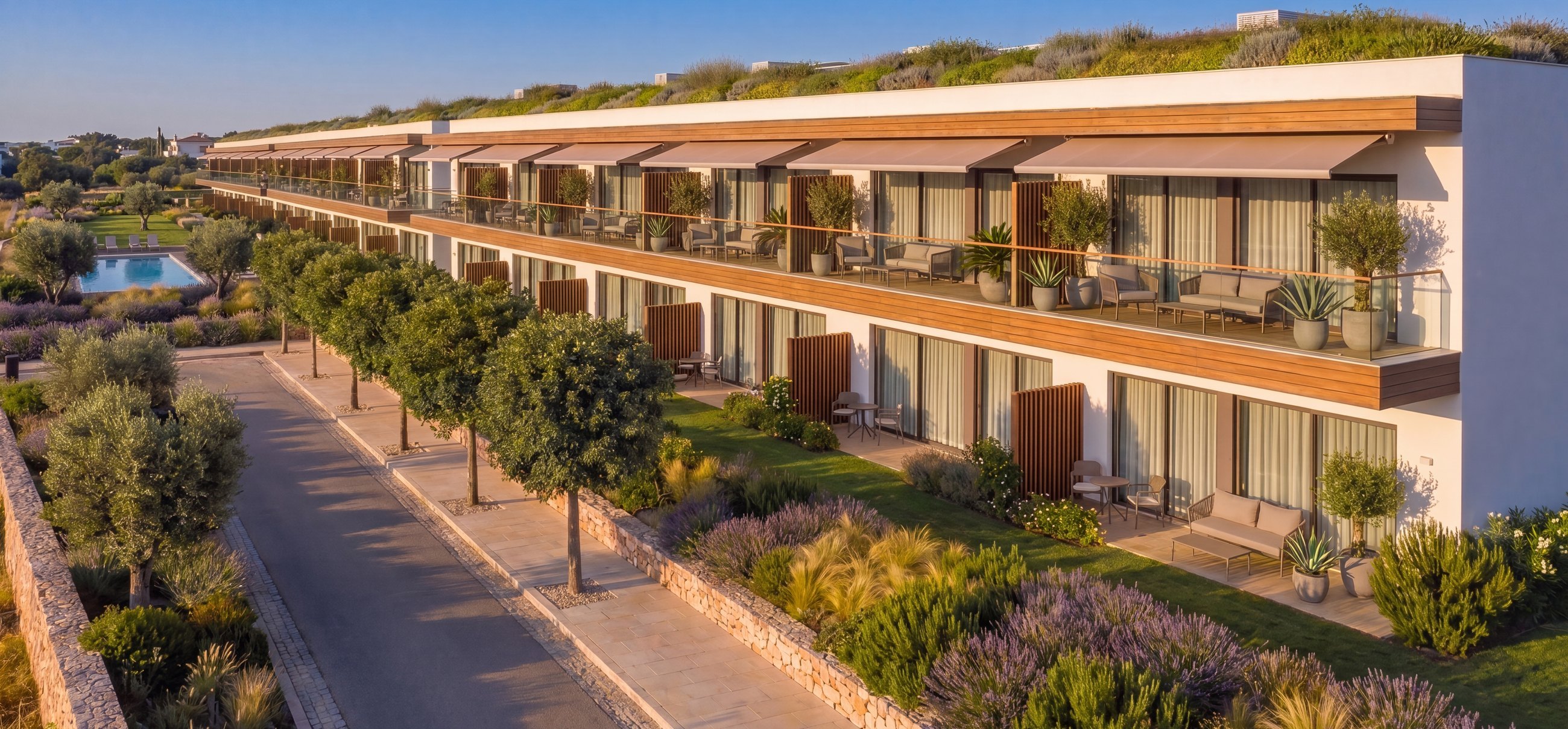 Apartmenthaus mit Terrassen, Markisen und begrüntem Dach in mediterraner Bepflanzung | Apartment building with terraces, awnings and a green roof amid Mediterranean planting