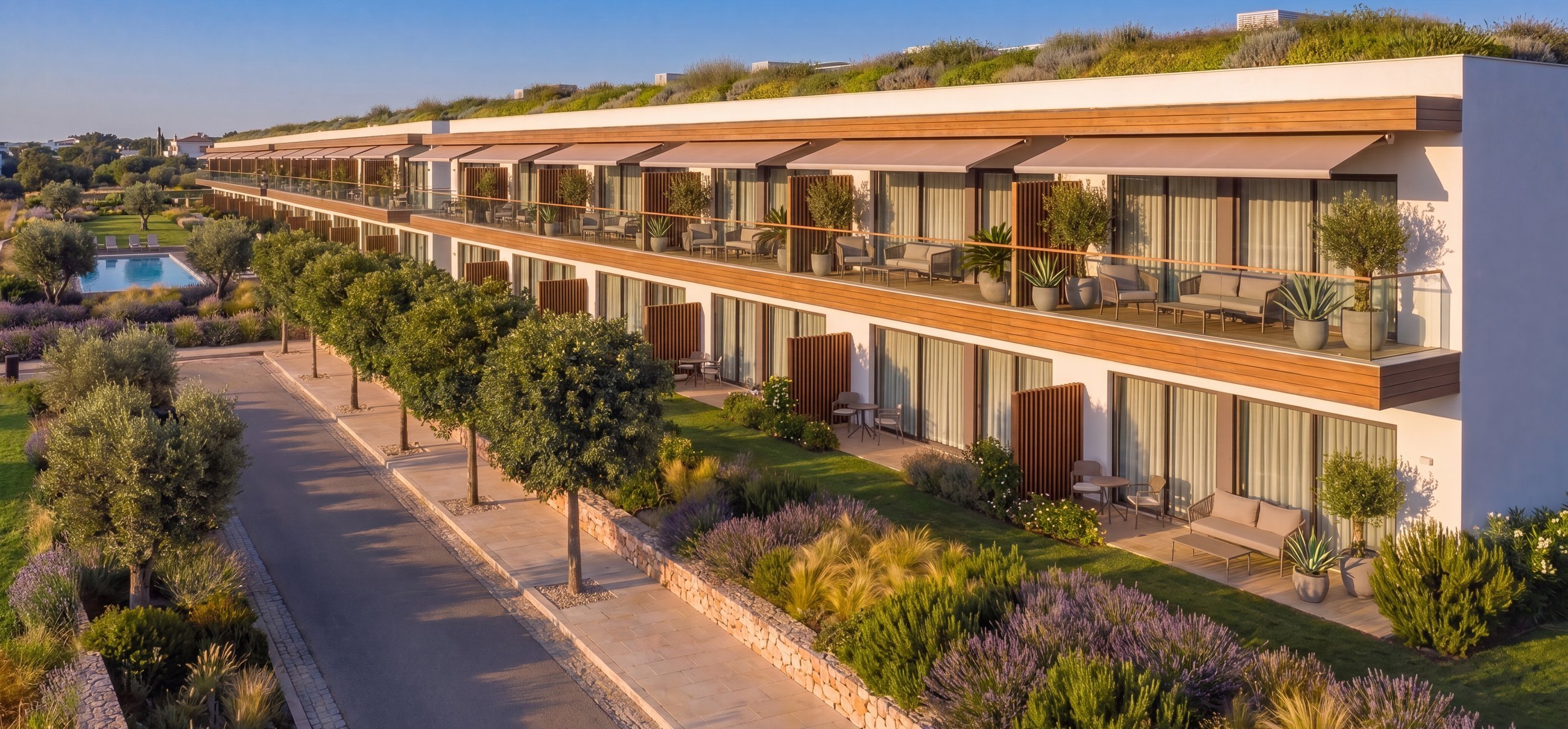 Apartmenthaus mit Terrassen, Markisen und begrüntem Dach in mediterraner Bepflanzung | Apartment building with terraces, awnings and a green roof amid Mediterranean planting
