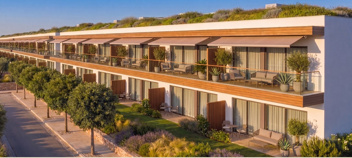 Apartmenthaus mit Terrassen, Markisen und begrüntem Dach in mediterraner Bepflanzung | Apartment building with terraces, awnings and a green roof amid Mediterranean planting