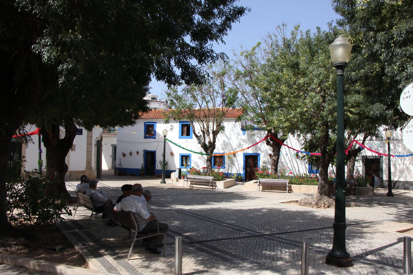 Schattiger Platz im Ortskern von Estoi mit Bänken und alten Bäumen | Shaded square in the centre of Estoi with benches and old trees